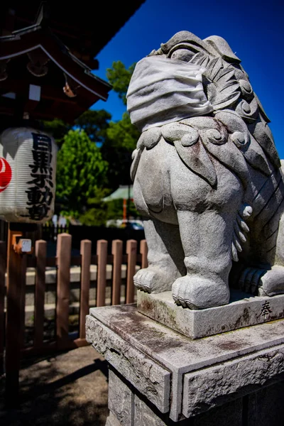 A statue of Guardian dog wearing mask at Meguro fudo temple in Tokyo