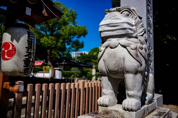 A statue of Guardian dog wearing mask at Meguro fudo temple in Tokyo