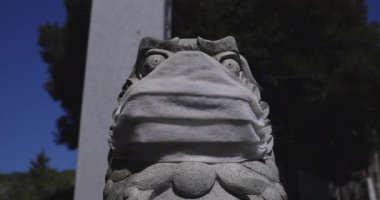 Tokyo 'daki Meguro Fudo Tapınağı' nda maske takan koruyucu köpek heykeli.