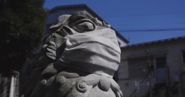 Tokyo 'daki Meguro Fudo Tapınağı' nda maske takan koruyucu köpek heykeli.