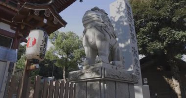 Tokyo 'daki Meguro Fudo Tapınağı' nda maskeli bir koruyucu köpek heykeli.