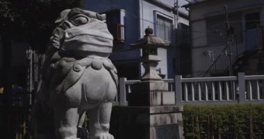 Tokyo 'daki Meguro Fudo Tapınağı' nda maske takan koruyucu köpek heykeli.