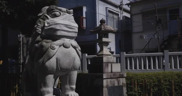 Una estatua del perro guardián con máscara en el templo Meguro fudo en Tokio de mano — Vídeo de stock