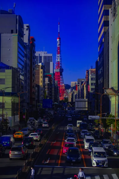 Un tráfico en la calle urbana detrás de la torre de Tokio tiro vertical —  Fotos de Stock