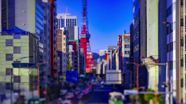 Un timelapse de tráfico en miniatura en la calle urbana detrás de la torre de Tokio tiltshift — Vídeo de stock