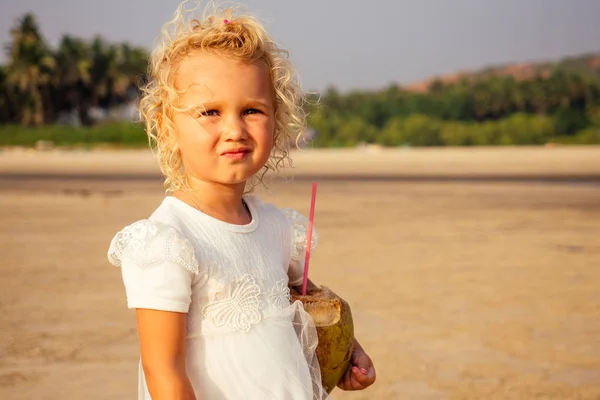 Маленькая девочка в белом платье идет по пляжу . — стоковое фото