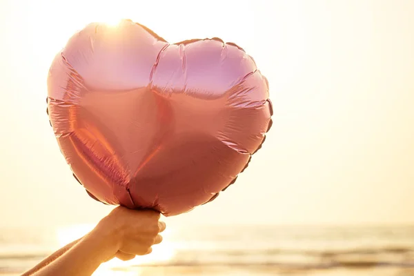 Gadis keriting kecil dengan balon merah muda di pantai saat matahari terbenam — Stok Foto