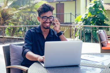 telefonda konuşan adam hindistan yaz tatilleri.şık genç hint erkek serbest dizüstü ile çalışan dizüstü serbest sörf online.işadamı sahilde uzak iş.dream job.online satın alma satış