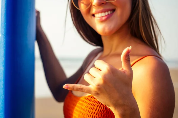 Finger hand symbols making a call phone me or aloha greetings surfers.girl surfer on the beach with surfboard — Stock Photo, Image