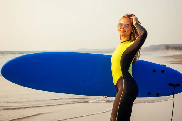 Młoda kobieta Freelancing w kombinezon pływanie nad deski surfingowej w wodzie na plaży. surfer dziewczyna relaksujący w raju wyspa zachód słońca romans i wolność Freelance w Oceanie Indyjskim. — Zdjęcie stockowe