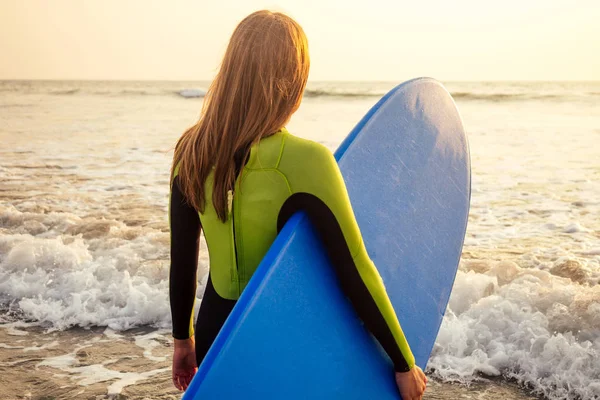 Donne attive con tavola da surf godere di sport acquatici in vacanza holidays.sport ragazza nella scuola di surf istruttore di windsurf. turista modello femminile in muta subacquea sulla spiaggia nell'Oceano Indiano — Foto Stock