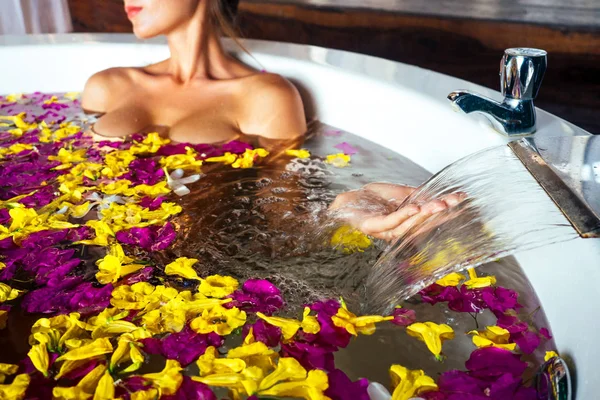 Touristen sexy Mädchen, die ein Bad mit tropischen Blumen im Urlaub in einem exotischen Sommer country. Junge schöne Frau in runden Jacuzzi Öko-Hotel Wellness-Salon entspannende Aromatherapie und Massage Frauentag — Stockfoto