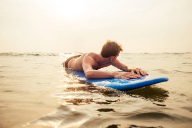 suda sörf keyfi yakışıklı genç adam.sörf tahtası sahilde sörf okyanusta erkek sörfçü, Hindistan Goa ocean sörf tahtası üzerinde sürüklenen serbest serbest erkekler.özgürlük ve adrenalin kavramı
