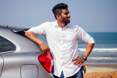 Hintişadamı deniz plajı yaz iyi gün araba açık havada duran.beyaz gömlek ve kar beyazı gülümseme bir adam okyanus kenarında bir tatil zevk yeni bir araba satın seviniyor