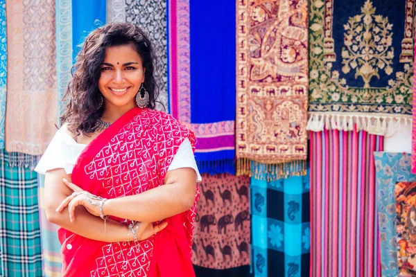 Business lady in red traditional sari and jewelry clothes shop owner cashmere yak wool shawls Delhi market.female seller in goa india arambol sale shop.designer seamstress tailor girl in Arambol Goa — стоковое фото