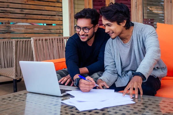 Indiano jovens empresários empresário freelancer trabalhando ao ar livre chaise lounge na praia com laptop.two amigos de sucesso freelancer surf remoto trabalho férias de verão no paraíso tropical . — Fotografia de Stock