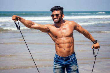 sahilde mutlu genç Afrikalı adamın portresi. Yakışıklı ve kendine güvenen Erkeksi sert fitness modeli erkek vücut geliştirmeci altı paketi ile. Mükemmel abs, omuzlar, pazı, triceps, göğüs ile Hindistan eğitmen