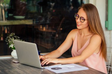 Web Designer uzaktan çalışma konsepti. Başarılı şık kadın turist modern dizüstü bilgisayar deniz kıyısında kahve dükkanı kafe restoranda bir masada oturan çalışan.freelance serbest uzaktan çalışma