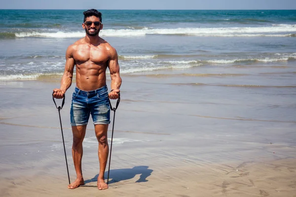 Hermoso musculoso moreno surfista atlético musculoso y saludable hombre negro en la playa durante el verano por la mañana calentamiento océano india mar Goa vacaciones —  Fotos de Stock