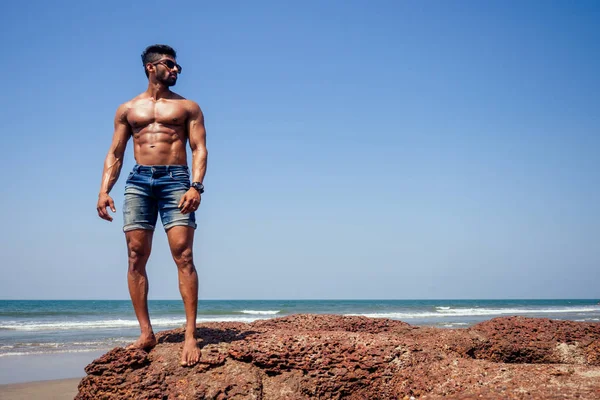 Schöner muskulöser dunkelhaariger Surfer athletisch muskulöser und gesunder schwarzer Mann am Strand während des sommerlichen Morgens aufwärmen Ozean Indien Meer Goa Urlaub — Stockfoto