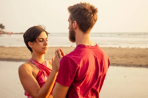 sahilde muladhara swadhisthana manipula tantra yoga adam ve kadın gün batımında deniz kenarında kum üzerinde oturan meditasyon romantik Sevgililer Günü.couple yoga buhar pratik
