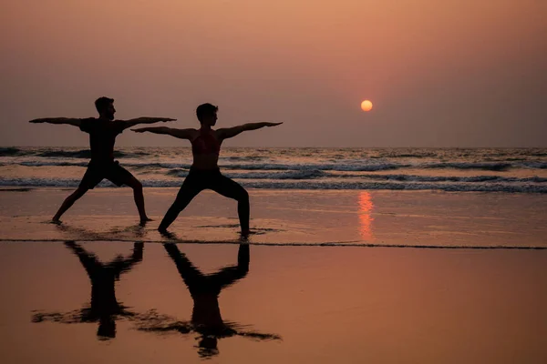 Muladhara swadhisthana manipula tantra yoga на пляже мужчина и женщина meditates сидя на песке у моря на закате романтичный Валентин Дай. — стоковое фото