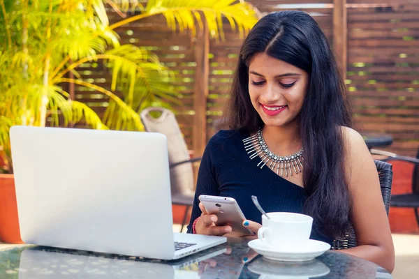 Идея кофе-брейка. Молодая индийская предпринимательница пользуется планшетным компьютером в летнем кафе в саду — стоковое фото