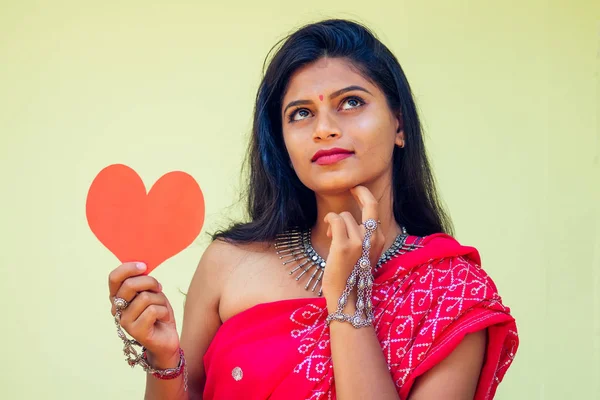 Hermosa mujer india en saree verde sosteniendo un corazón de papel tarjetas de felicitación tarjeta de San Valentín símbolo del corazón en la playa.Valentine —  Fotos de Stock