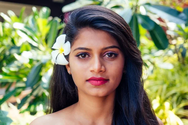 Mujer india aplicando aceite de coco morena oscura pelo largo en una mano en verde verano parque naturaleza tropical —  Fotos de Stock