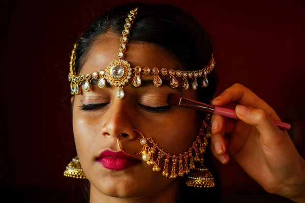 Indiana bela fêmea em jóias ricas em ouro e tradição saree rosto close-up maquiagem profissional vestindo bindi na cabeça .Artist fazendo a muslimgirl com bindis maang tikka, nath, nariz Pin — Fotografia de Stock