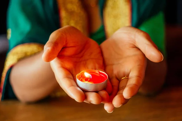 Woman lighting diyas with nuth nath nose piercing and the golden teak with traditionak fashion sari — Stock Photo, Image