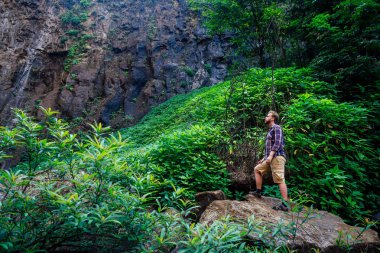 sırt çantası ile rahat genç adam dere tarafından ayakta. dere Hindistan Karnataka Kerala tarafından erkek yürüyüş