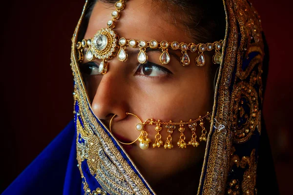 Retrato indio hermosa mujer en joyas ricas en oro y tradición cara saree primer plano maquillaje profesional con bindi en la cabeza. Retrato de la cara de la mujer musulmana con bindis maang tikka, nath, nariz Pin —  Fotos de Stock