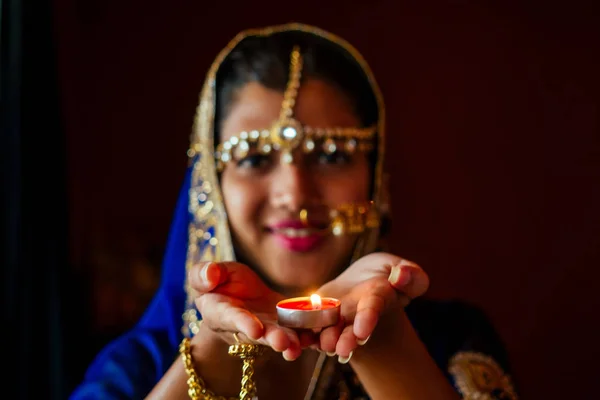 Mujer iluminación diyas con nuth nath piercing en la nariz y la teca de oro con Traditionak sari moda —  Fotos de Stock