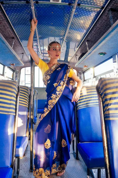 Retrato indio hermosa mujer caucásica en modelo dress.hindu azul tradicional con joyas de oro conjunto pendientes de bindi y piercing anillo de la nariz debajo de la sesión de fotos de moda en autobús —  Fotos de Stock