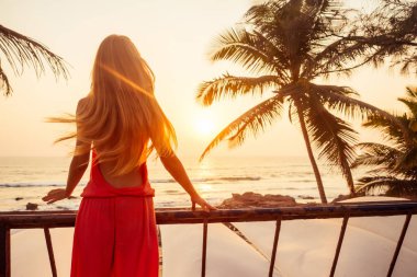 Şık pembe tulum palmiye ağacı ve gün batımı portre uzun saç sarı güzellik çarpıcı seksi model