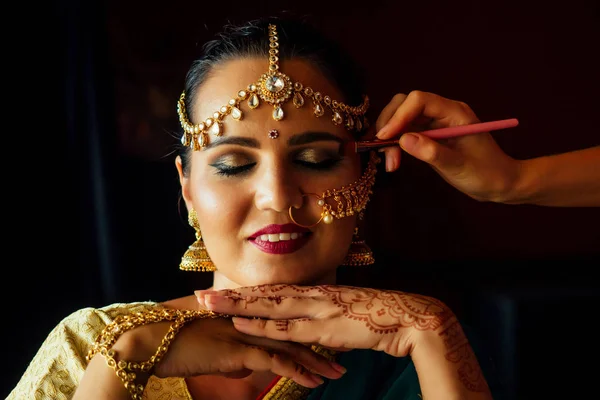 Ritratto indiano bella femmina in oro ricchi gioielli tradizione saree viso primo piano professionale make-up indossa bindi sulla testa, con bindis maang tikka, nath, naso Pin.morning della sposa visagiste — Foto Stock