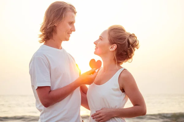 Silueta de amantes románticos abrazo con mar océano con puesta de sol con el símbolo del corazón rojo - San Valentín concepto Día — Foto de Stock