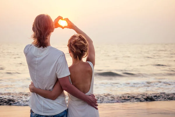 Silueta de amantes románticos abrazo con mar océano con puesta de sol con el símbolo del corazón rojo - San Valentín concepto Día —  Fotos de Stock