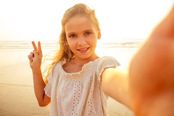 Очаровательная маленькая девочка фотографируется по телефону — стоковое фото