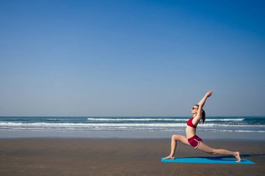Mavi sahilde yoga yapan beyaz kadın