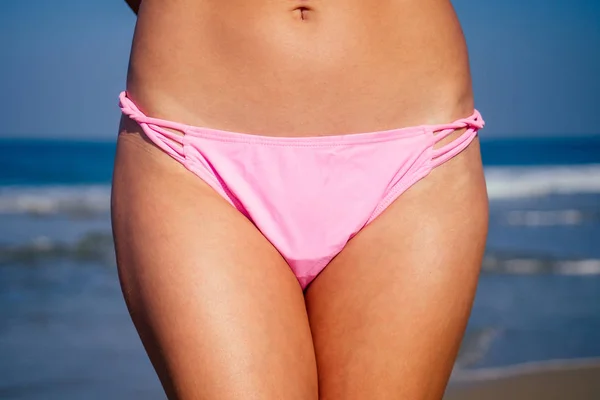Schöner gebräunter Bauch eines Mädchens auf dem Ozean — Stockfoto