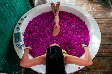 Lüks otel tatil beldesinde tropikal çiçekler açık banyoda rahatlatıcı Kadın seksi esmer. Organik cilt sağlığı. Güzel kız otel spa masaj ve meditasyon.womens Day 8 Mart dinlenme