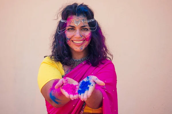 Kvinnlig indisk modell Snövit leende på Holi Color Festival. Indisk kvinna i traditionell Sari klänning med svart lockigt hår i en rosa och blå färg och Bindi smycken firar Holi Color Festival — Stockfoto