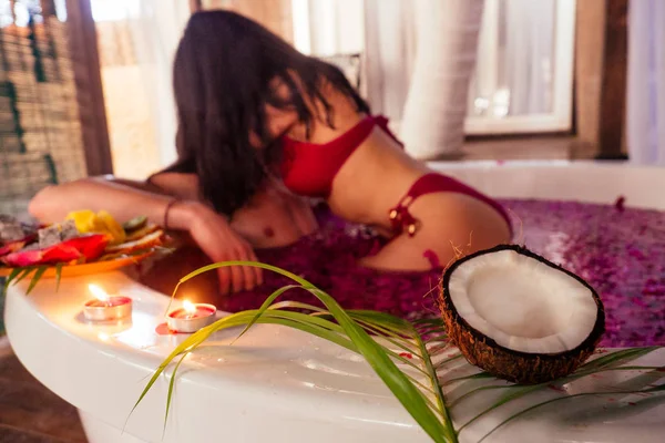 Homem e mulher beijando e abraçando frutas românticas, velas e champanhe — Fotografia de Stock