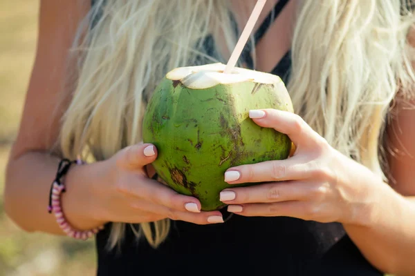 Sarışın bayan detoks elinde coco fındık su ve plastik tüp — Stok fotoğraf