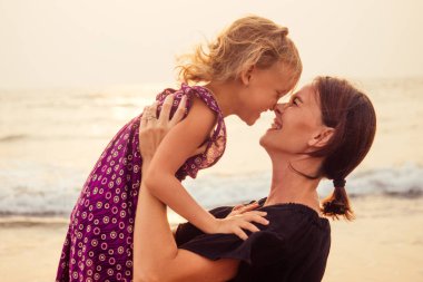 sahilde mutlu bir aile. anne sarılma çocuk kızı ve çocuklar ile turizm sinek.spf ve güneş kremi