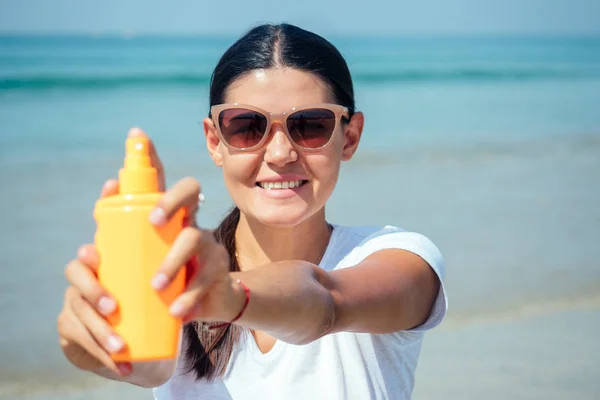 女性はビーチで日焼け止めの助けを借りて紫外線から保護されています — ストック写真