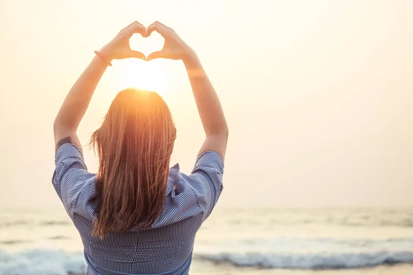 Güzel ve genç bir kadın plajda Rukmi 'nin kalbini tasvir ediyor.
