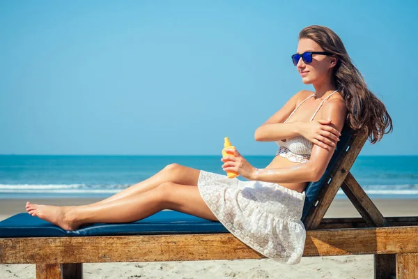 美しくセクシーな若い女性は海の上で体に日焼け止めを適用しています紫外線からの保護と休暇中の皮膚癌からの予防 — ストック写真